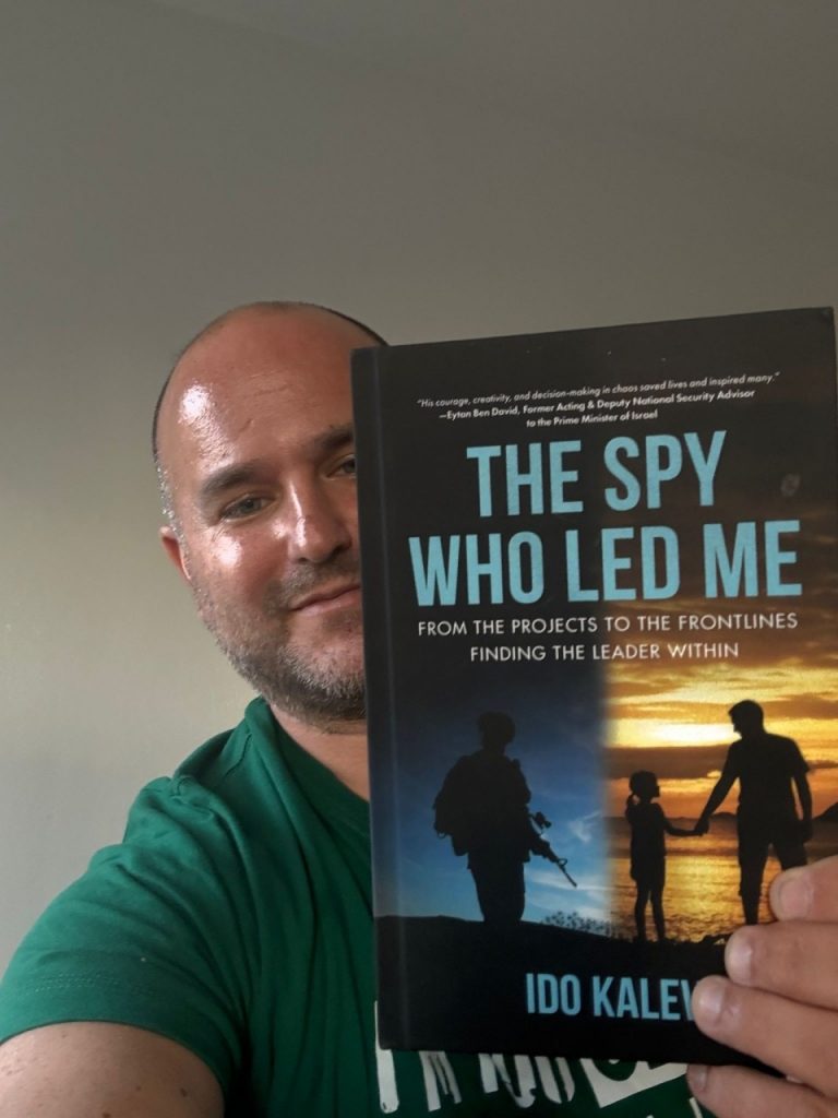 Ido Kalev holding a copy of his book