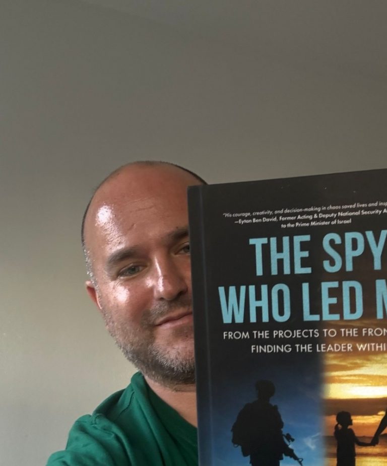 Author Ido Kalev holding a copy of his book