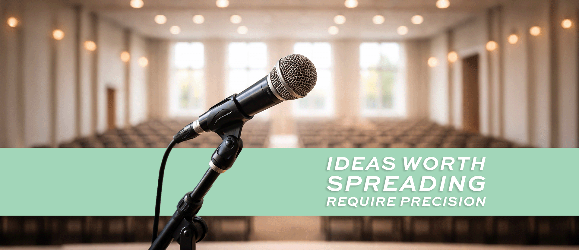 A banner image with a microphone on a stage overlooking an empty room with seats.